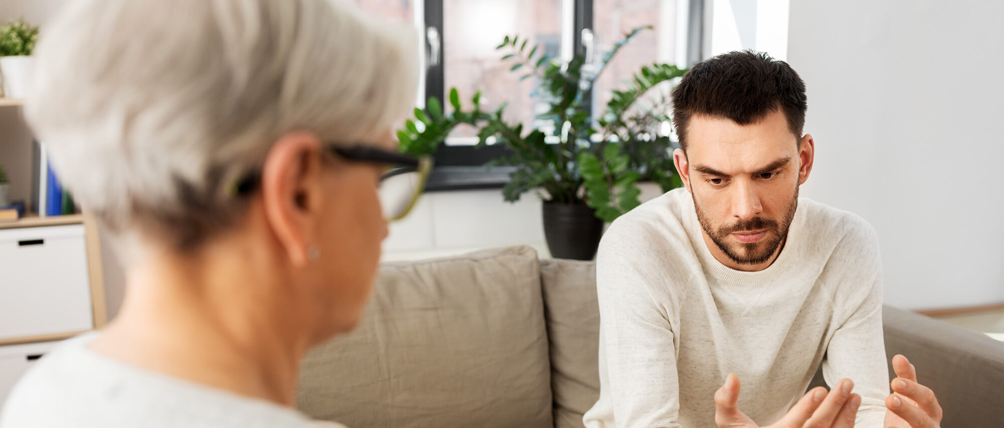Psicologa prende appunti durante la sessione di psicoterapia con un paziente giovane triste